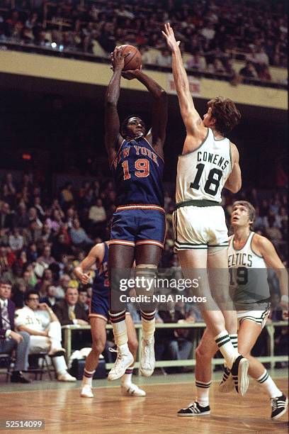 Willis Reed of the New York Knicks shoots over Dave Cowens of the Boston Celtics during an NBA game.