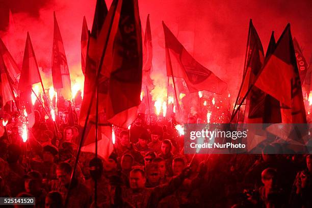 Activists and supporters of Ukrainian nationalists hold a torch and flags, as they march in downtown Kiev during a rally. The march was confined to...