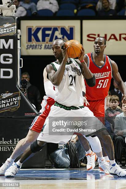 Kevin Garnett of the Minnesota Timberwolves is defended by Emeka Okafor of the Charlotte Bobcats during the game at Target Center on March 8, 2005 in...