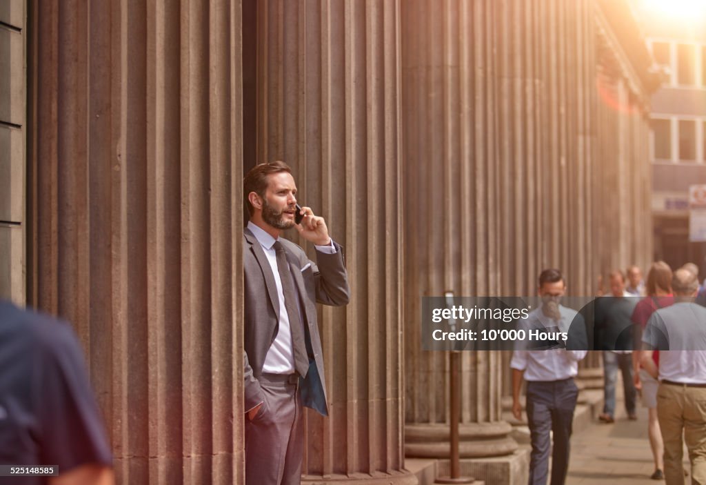 A businessman in the city talking on phone