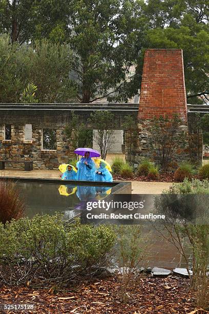 Family stands at the memorial pool, with the Broad Arrow cafe behind them during the 20th anniversary commemoration service of the Port Arthur...