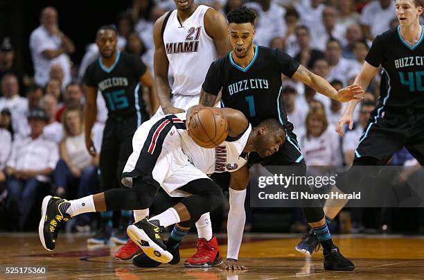 Miami Heat guard Dwyane Wade drives against Charlotte Hornets guard Courtney Lee during the first quarter on Wednesday, April 27 at AmericanAirlines...