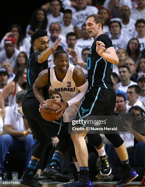 Miami Heat guard Dwyane Wade looks to pass against Charlotte Hornets guard Courtney Lee, left, and Cody Zelle during the fourth quarter on Wednesday,...