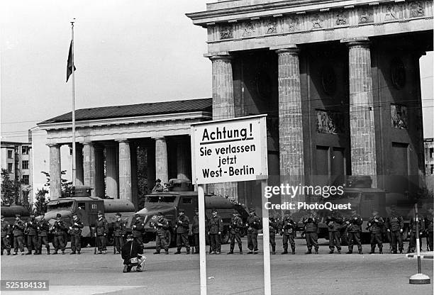 Backed by high-pressure water trucks and armored cars, East German soldirs bar traffic through the Brandenburg Gate in the center of divided Berlin,...