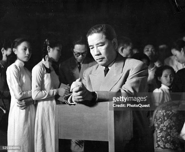 President Ngo Dinh Diem of Free Vietnam is seen kneeling during midnight Mass, held on grounds of the Presidential mansion palace, Saigon , Vietnam,...