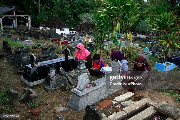 Residents pray at the tombs of their ancestors during Nyadran ritual in Sewu Cemetery on June 8, 2015 in Bantul, Yogyakarta, Indonesia. Nyadran...