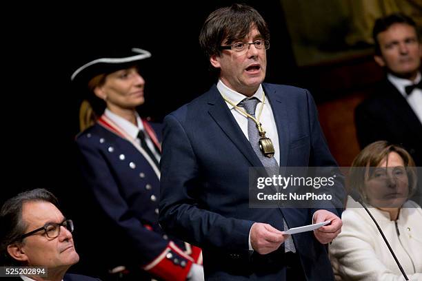 New Catalan President Carles Puigdemont looks down at a medal he received from outgoing Catalan President Artur Mas during Puigdemont's swearing-in...