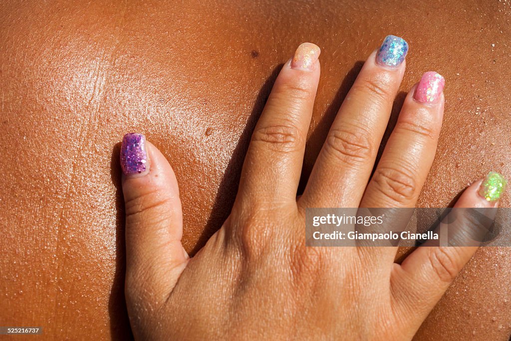 Colored nails on a tanned female body