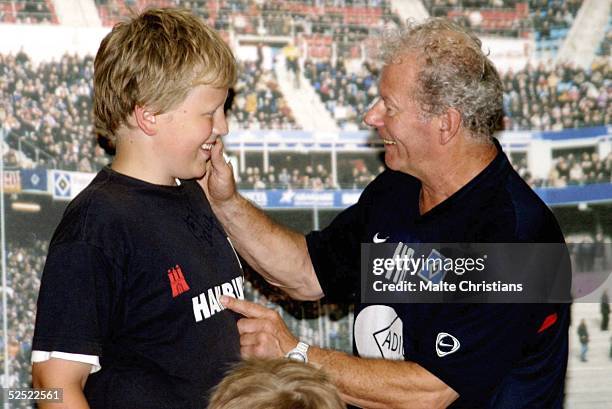 Fussball: HSV zum Anfassen, Hamburg; Autogrammstunde mit Herman Rieger; Herman RIEGER gibt einem jungen Fan ein Autogramm auf sein T-Shirt 13.08.04.