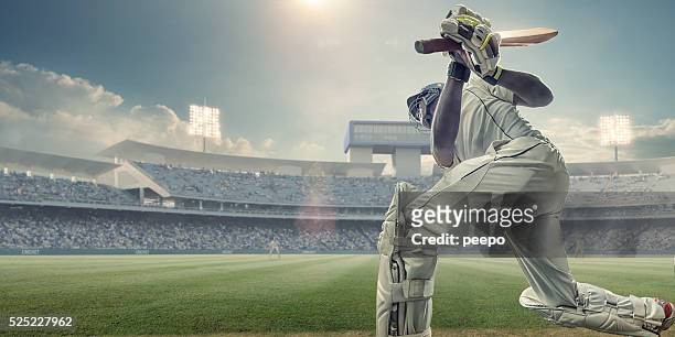 cricket batsman with bat up after hitting ball in game - cricket stock pictures, royalty-free photos & images