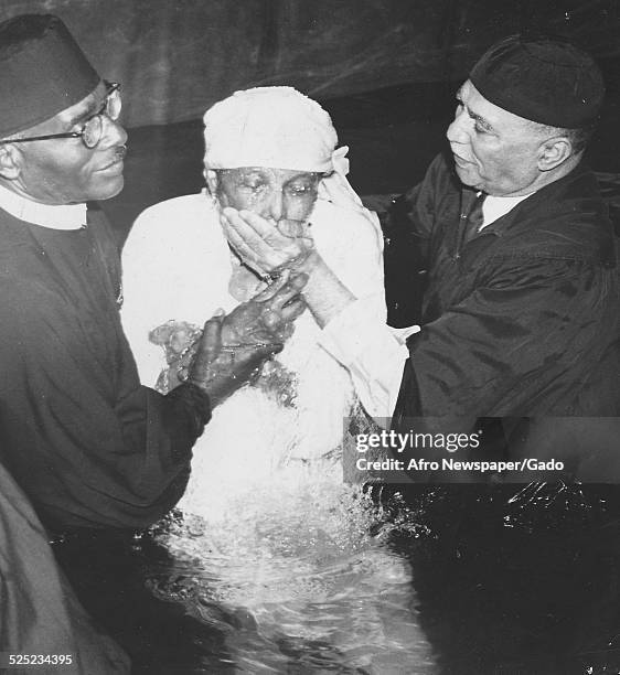 Convert and African-American Christian evangelist, faith healer, television personality and entrepreneur Lightfoot Solomon Michaux during a baptism,...