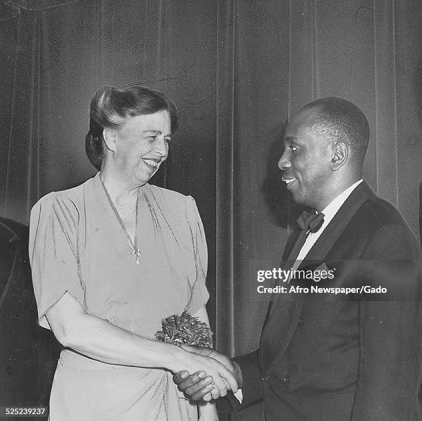 Former United States First Lady Eleanor Roosevelt shakes hands with author Howard Thurman during a banquet, June 3, 1944.