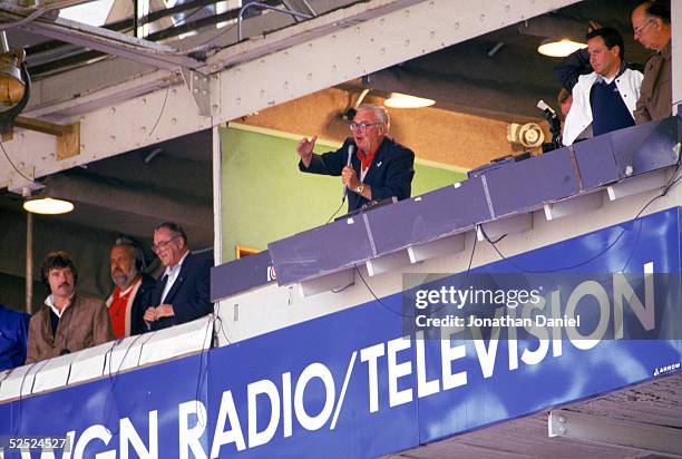 Chicago Cubs baseball announcer and Baseball Hall of Fame inductee Harry Caray conducts fans singing "Take Me Out to the Ball Game" from his...