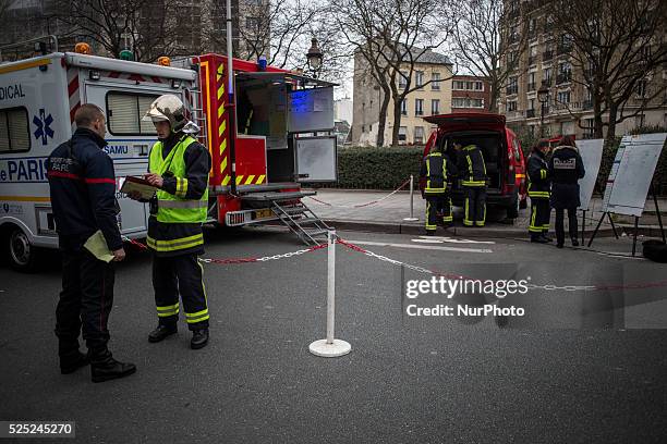 Ambulances and police officers gather in front of the offices of the French satirical newspaper Charlie Hebdo on January 7, 2015 in Paris, France....