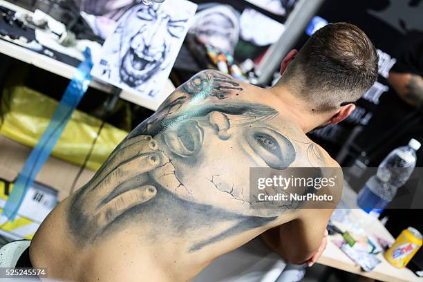 Man poses with his tattoo on his back during the Italian Tattoo Artists Convention at the Palavela, on September 19, 2015 in Turin. Until Sunday,...