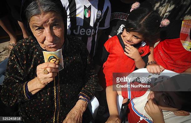 Christian refugee kisses an icon of the Virgin Mary as she tells the other refugees about her journey fleeing Mosul from the terror group Islamic...