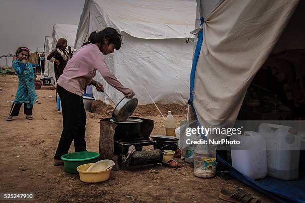 Little girl made food in a camp on the southern outskirts of the northern Syrian city of Aleppo on October 22, 2015. Tens of thousands of Syrians...