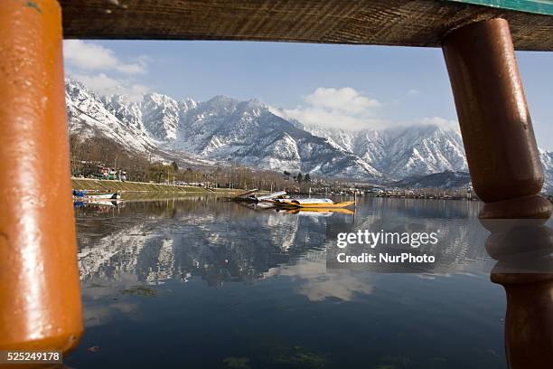 Snow capped Zabarvan mountains are reflected in Dal lake on March 10, 2015 in Srinagar, the summer capital of Indian administered Kashmir, India....