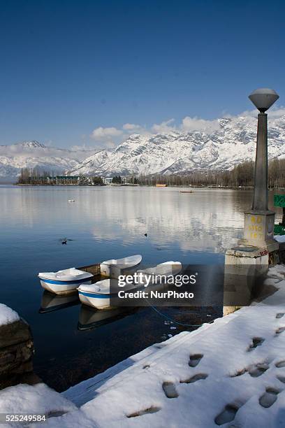 Snow capped Zabarvan mountains are reflected in Dal lake on March 10, 2015 in Srinagar, the summer capital of Indian administered Kashmir, India....