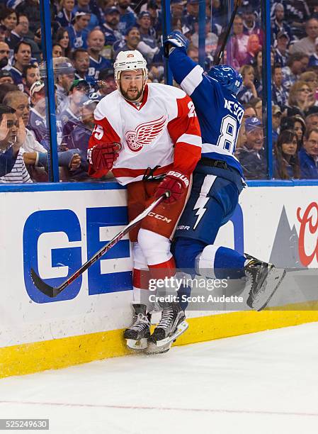 Nikita Nesterov of the Tampa Bay Lightning attempts a check against Mike Green the Detroit Red Wings during the first period of Game Five of the...