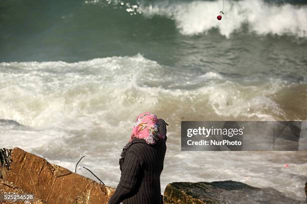 Palestinians throw flowers into the sea, in remembrance of the Chapel Hill shooting victims, in Gaza City, February 14, 2015. Three young Muslims...