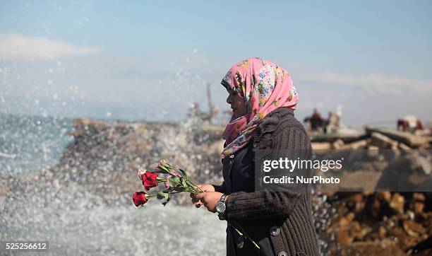 Palestinians throw flowers into the sea, in remembrance of the Chapel Hill shooting victims, in Gaza City, February 14, 2015. Three young Muslims...