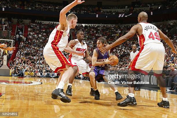 Steve Nash of the Phoenix Suns drives against Michael Doleac, Keyon Dooling and Shandon Anderson of the Miami Heat on March 25, 2005 at American...