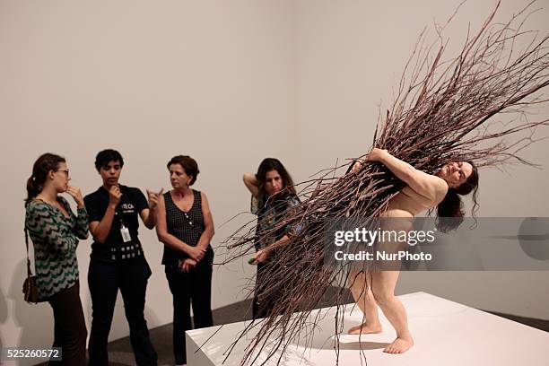 Visitors look at the sculpture entitled &quot;Woman with Sticks&quot; by the Australian artist Ron Mueck during his exhibition at the Pinacoteca of...