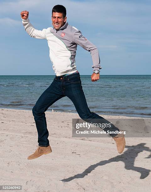 Novak Djokovic of Serbia holds the winners trophy on the beach after defeating Rafael Nadal of Spain at the Men's Final on day 14 of the Sony Open