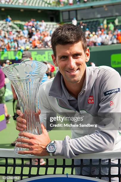 Novak Djokovic of Serbia holds the winners trophy on the beach after defeating Rafael Nadal of Spain at the Men's Final on day 14 of the Sony Open