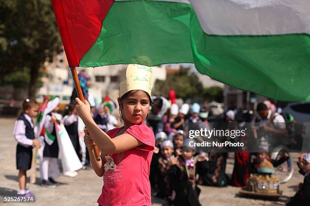 Palestinians children raise the Palestinian flag during a ceremony in Gaza City, on October 1, 2015. The Palestinian flag was raised at UN...