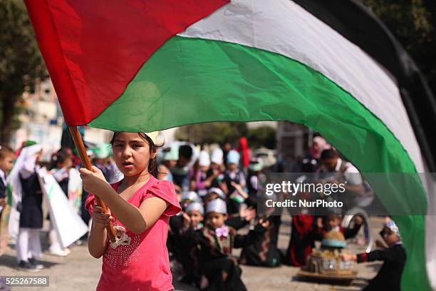 Palestinians children raise the Palestinian flag during a ceremony in Gaza City, on October 1, 2015. The Palestinian flag was raised at UN...