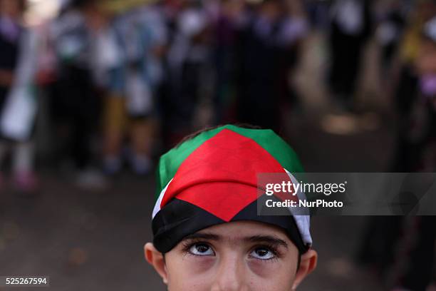 Palestinians children raise the Palestinian flag during a ceremony in Gaza City, on October 1, 2015. The Palestinian flag was raised at UN...