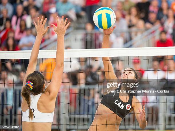 Melissa Humana-Paredes of Canada spikes the ball past Fabian Gomez of Uruguay during the the preliminary rounds of beach volleyball competition at...