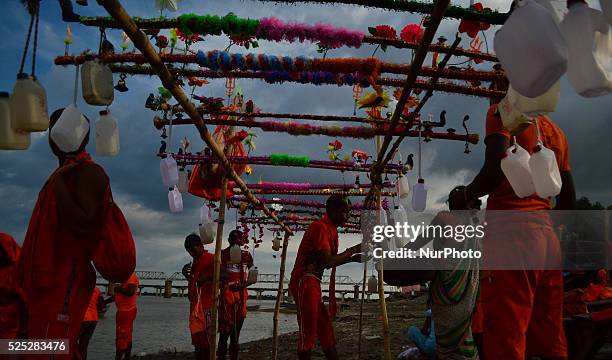 Indian hindu devotees prepare for their Kanwar yatra as they take holy water of River Ganga in plastic containors , on the sacred month of Shravan at...