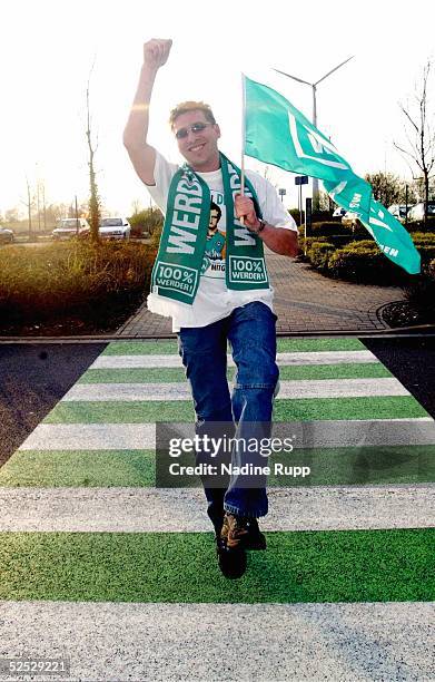 Fussball: 1. Bundesliga 03/04, Bremen; SV Werder Bremen Fan Feature; Werder-Fan Mike NEUMANN auf einem gruen-weissen Zebrastreifen. DHL-Mitarbeiter...