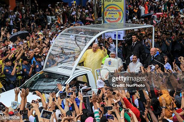 Pope Francis waves to the crowd after conducting mass in Manila on January 18, 201. Pope Francis is visiting venues across Leyte and Manila during...