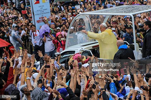 Pope Francis waves to the crowd after conducting mass in Manila on January 18, 201. Pope Francis is visiting venues across Leyte and Manila during...