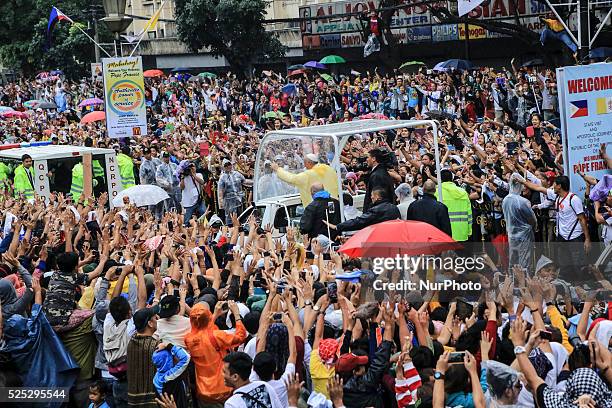 Pope Francis waves to the crowd after conducting mass in Manila on January 18, 201. Pope Francis is visiting venues across Leyte and Manila during...