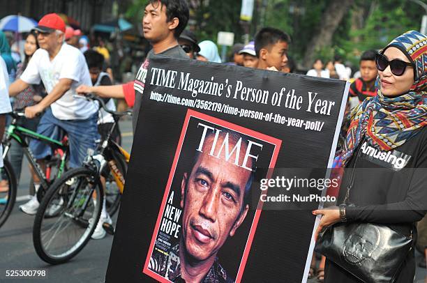 November 23 : People take pictures with posters of the cover of TIME magazine during a promote Indonesian President, Joko Widodo in the voting of...