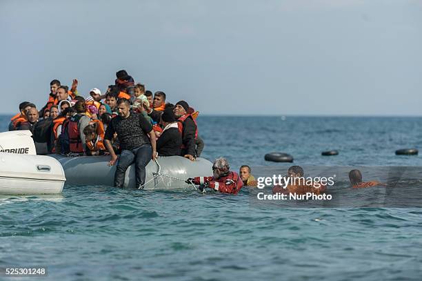 Refugees and migrants massed onto an inflatable boat reach Mytilene, northern island of Lesbos, after crossing the Aegean sea from Turkey on February...