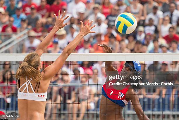 Taylor Pischke of Canada attempts a block against Leila Martinez of Cuba during Canada vs. Cuba in beach volleyball competition at the 2015 PanAm...