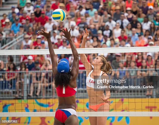 Taylor Pischke of Canada spikes the ball past Lianma Flores of Cuba during Canada vs. Cuba in beach volleyball competition at the 2015 PanAm Games in...