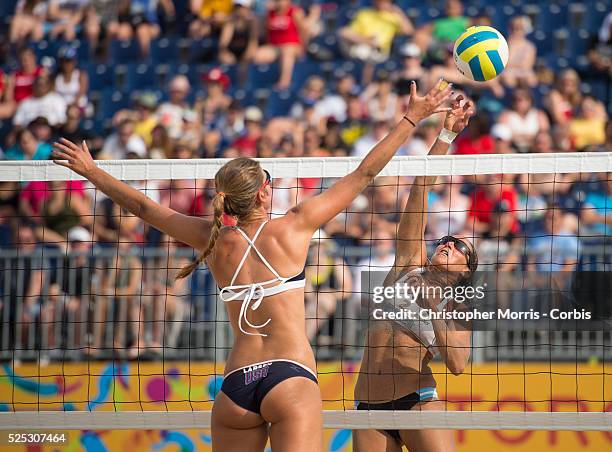 Ana Gallay of Argentina spikes the ball past Kelley Larsen of the USA during beach volleyball competition between USA and Argentina at the 2015 PanAm...