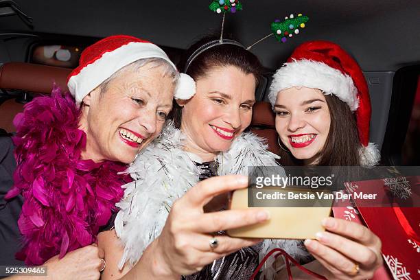 women taking selfies wearing christmas hats in car - boa stock pictures, royalty-free photos & images