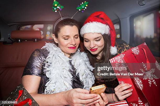 mother and daughter looking at phone in car. - car wrapping foto e immagini stock