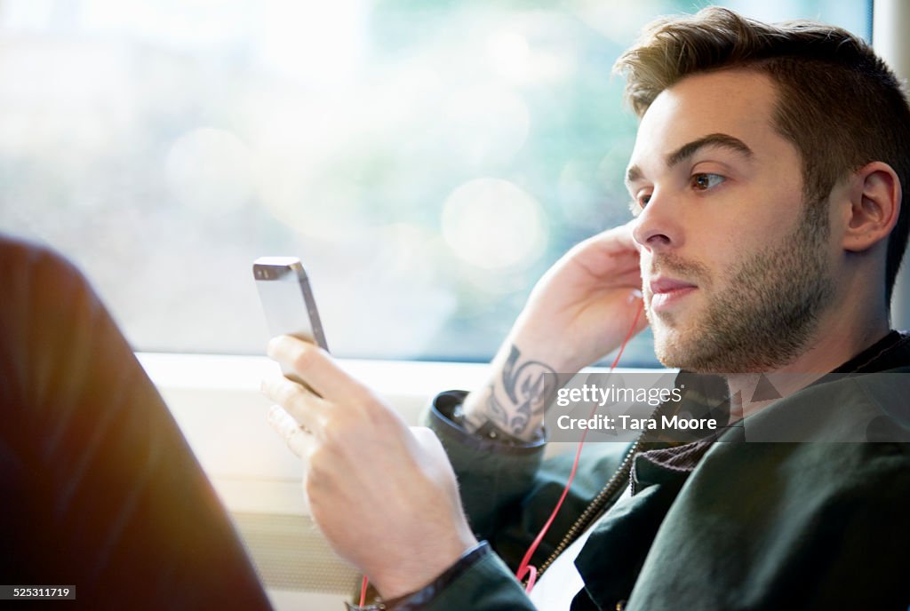 Trendy man on train with mobile phone