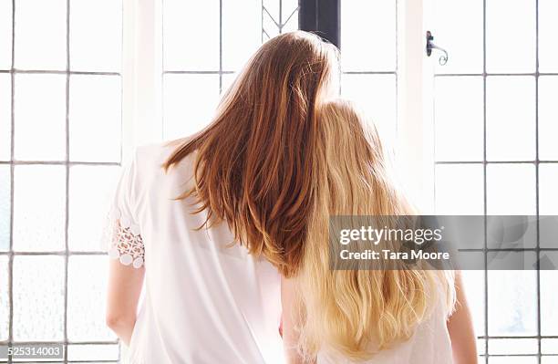 two girls leaning on each other - vestito bianco foto e immagini stock