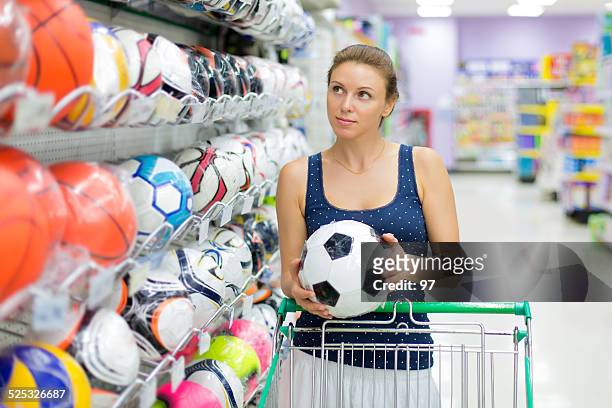 woman buys a soccer ball - sportswear shopping stockfoto's en -beelden