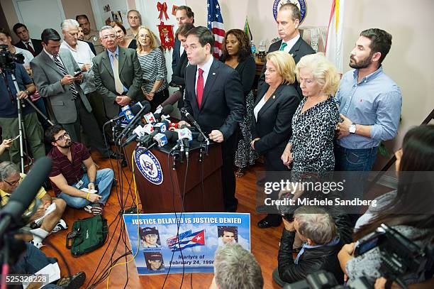 Sen. Marco Rubio stands near a poster with pictures of those lost from the group called 'Brothers to the Rescue' when they were shot down by Cuban...